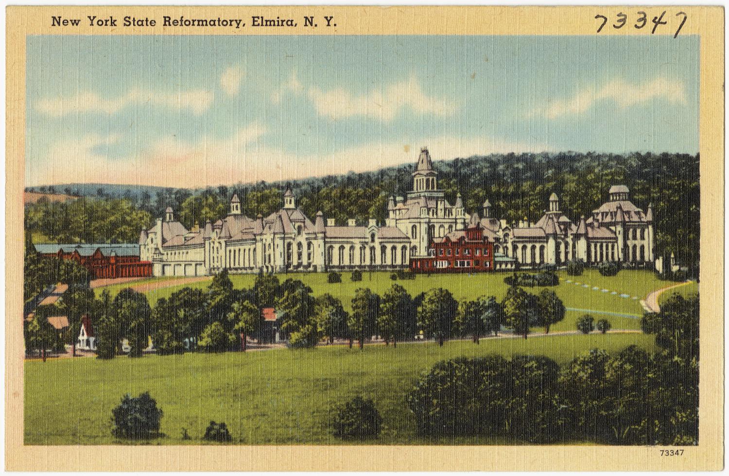 Postcard showcasing the striking Elmira Reformatory, built in the Richardsonian Romanesque architectural style with a distinct American interpretation. The exterior boasts imposing stone walls, punctuated by watchtowers featuring crenellations and decorative elements reminiscent of medieval fortifications. These watchtowers, strategically placed along the perimeter, provide both surveillance and architectural character to the facility. The facility is surrounded by lush trees, under a gently clouded sky.